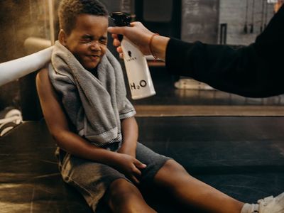 Close-up of a water bottle and towel on gym floor